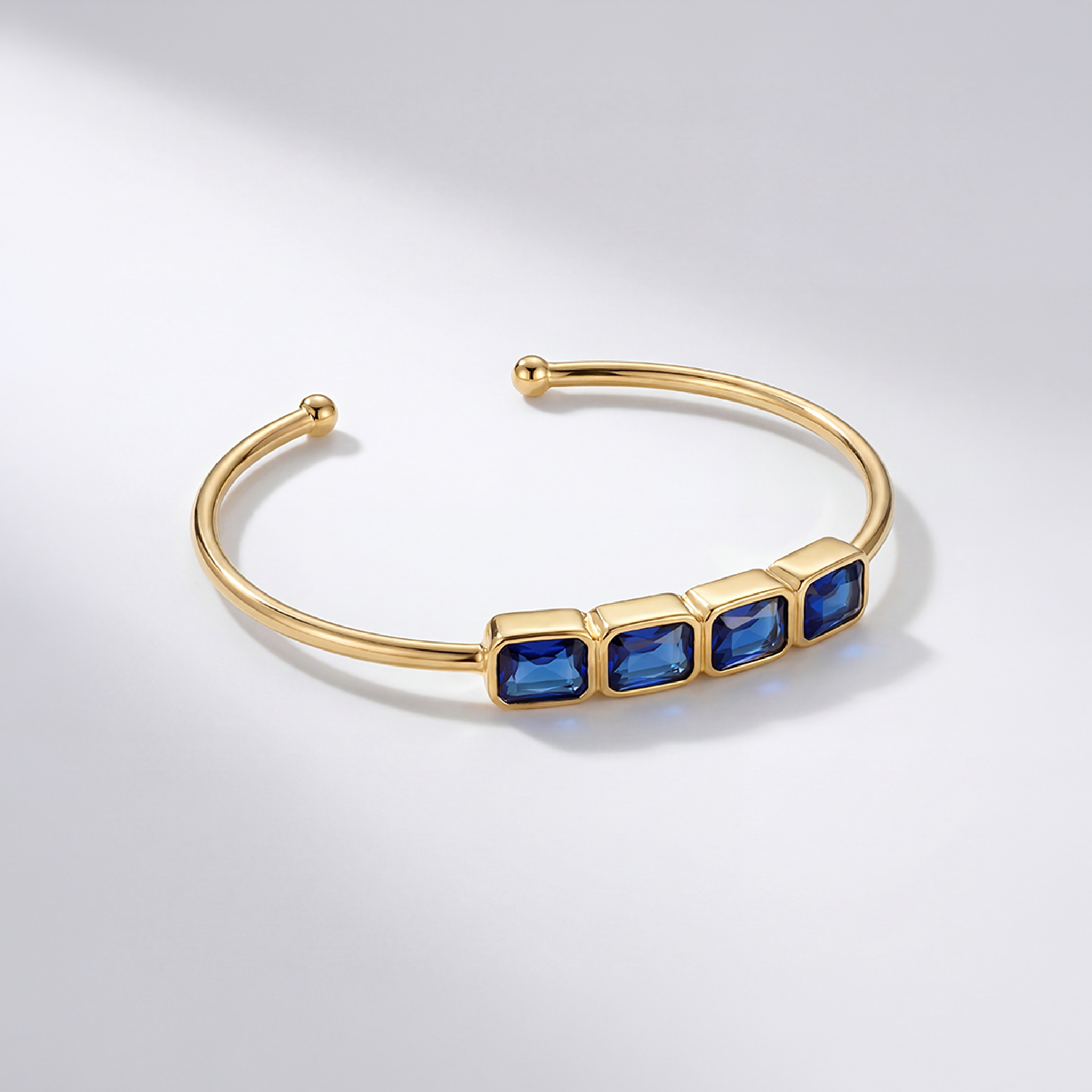 RB Jewelry Linear Cuff - gold open cuff bracelet with row of blue stones